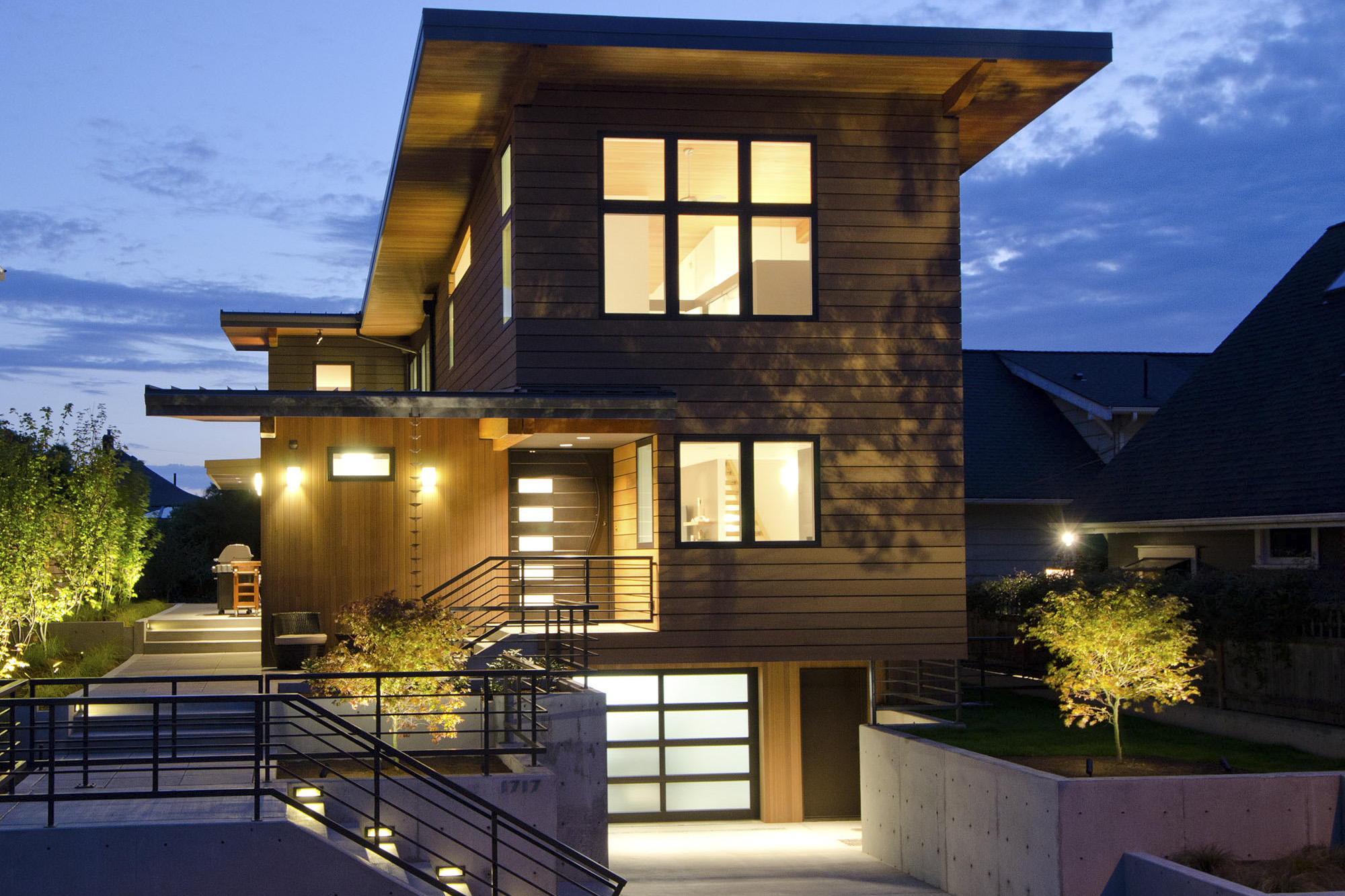Second slide - Modern home with butterfly roof clad in cedar and rainscreen at night