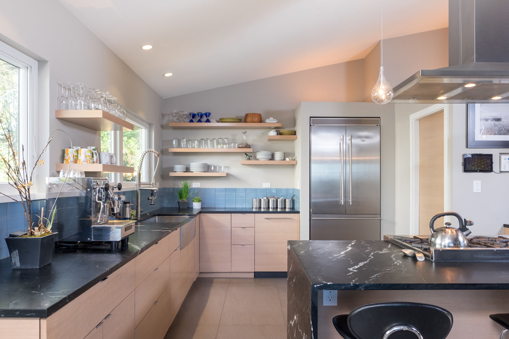 Sixth slide - Modern kitchen with soapstone counters and light wood and tile accents